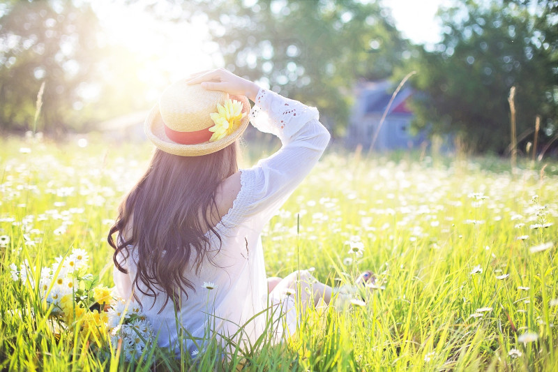 A woman sitting surround by green nature.